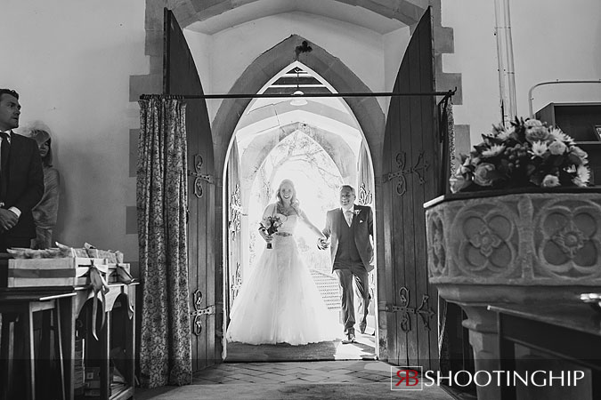 bride enters church with her father