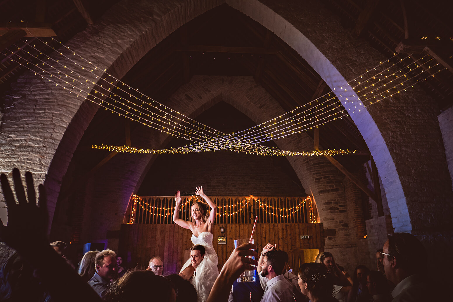 Bride on shoulders at Tithe Barn