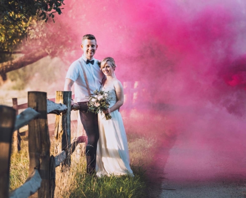 Bride and Groom with smokebombs on a country lane