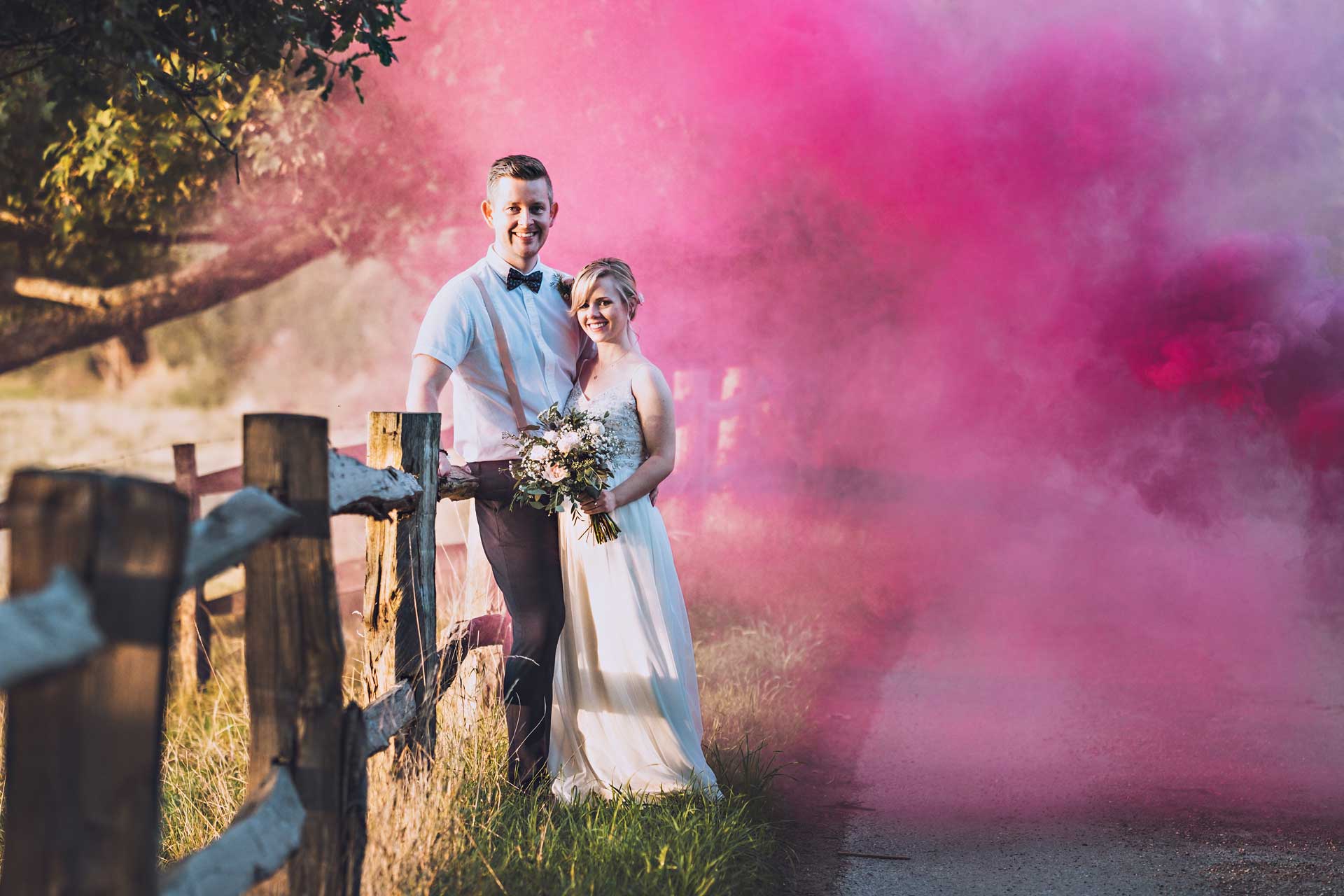 Bride and Groom with smokebombs on a country lane